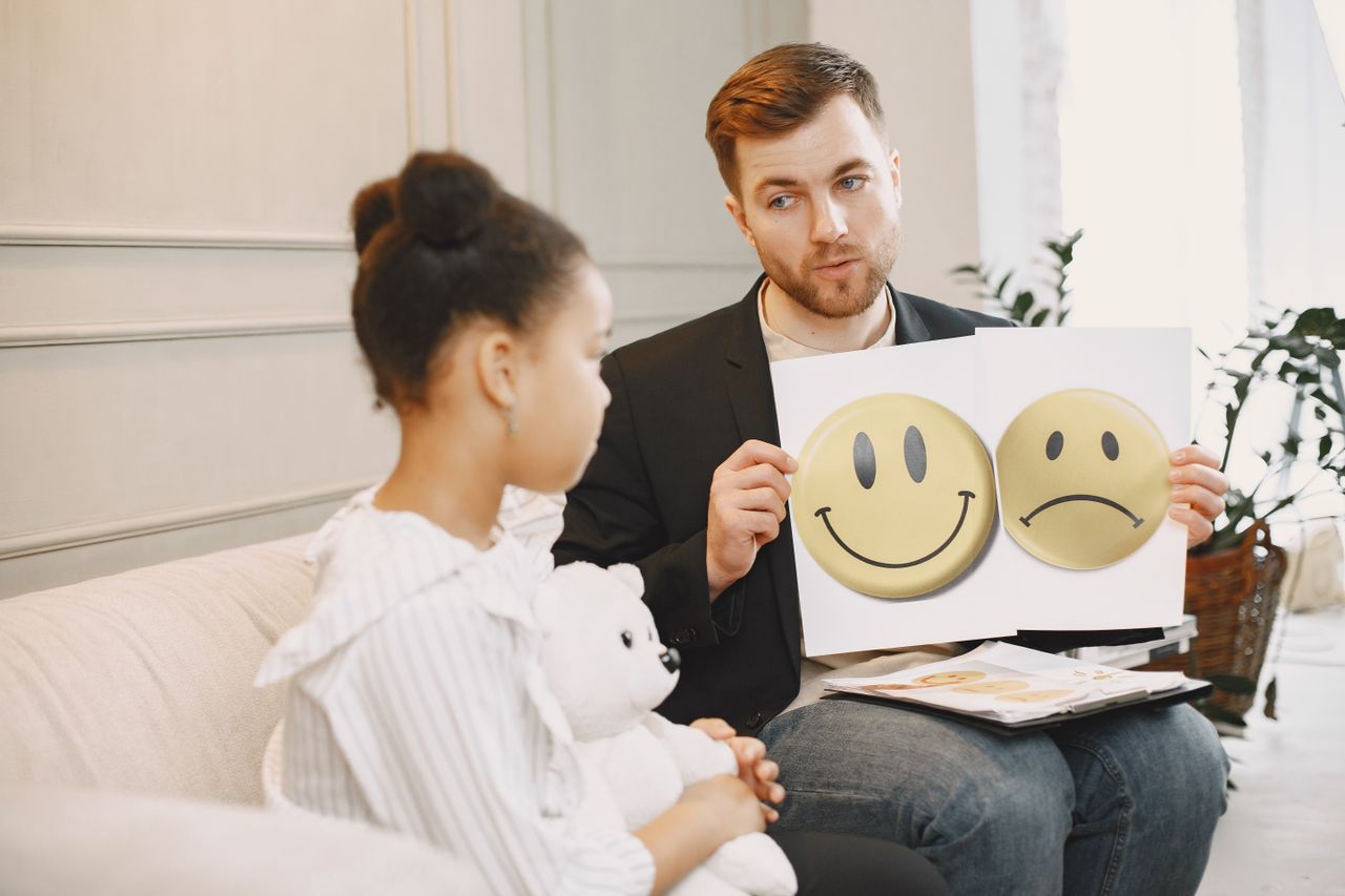 Services A therapist uses emotion cards to help a child express feelings during a counseling session.